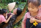 Poor single mother in the countryside takes care of the garden and breastfeeds her child.